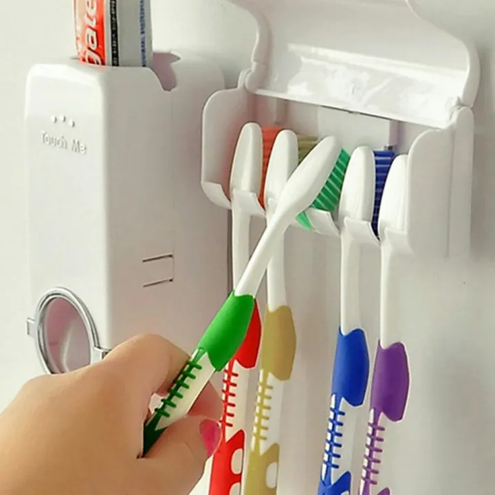 Five toothbrushes stored in the wall-mounted holder under its dust cover